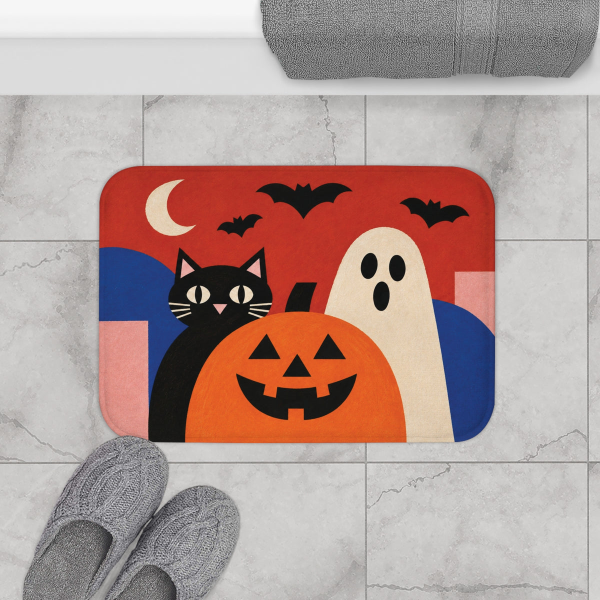 AmazerBath Halloween bath mat with retro black cat, white ghost, and pumpkin on light tile beside a white bathtub.
