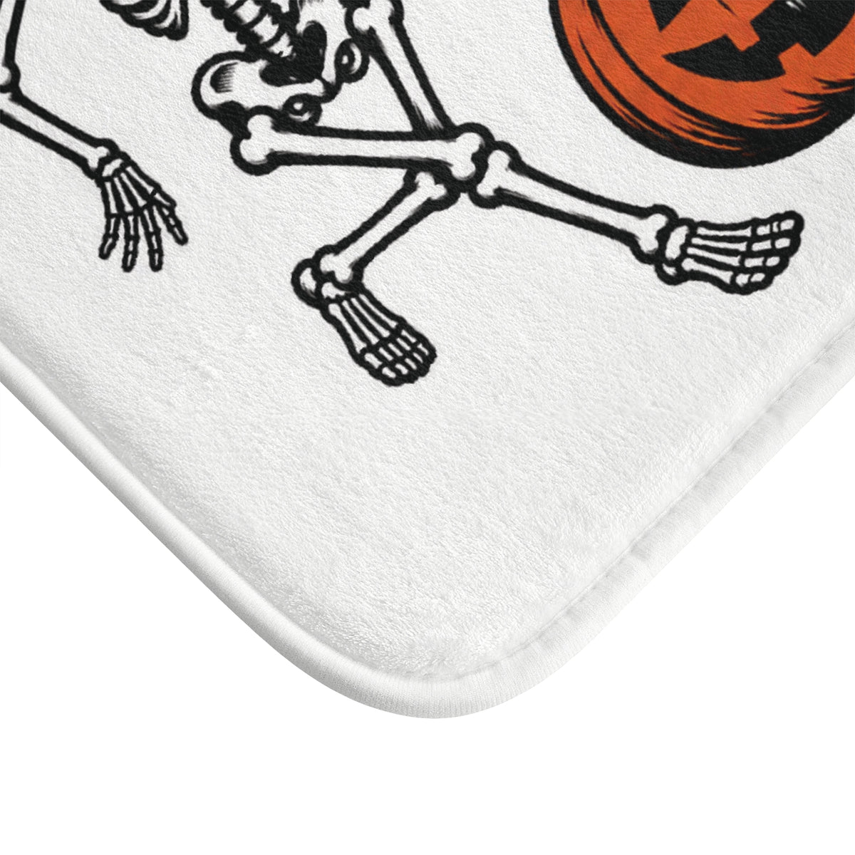 AmazerBath Halloween bath mat corner with dancing skeletons with jack-o'-lanterns, vivid print, soft texture, and a bound edge.