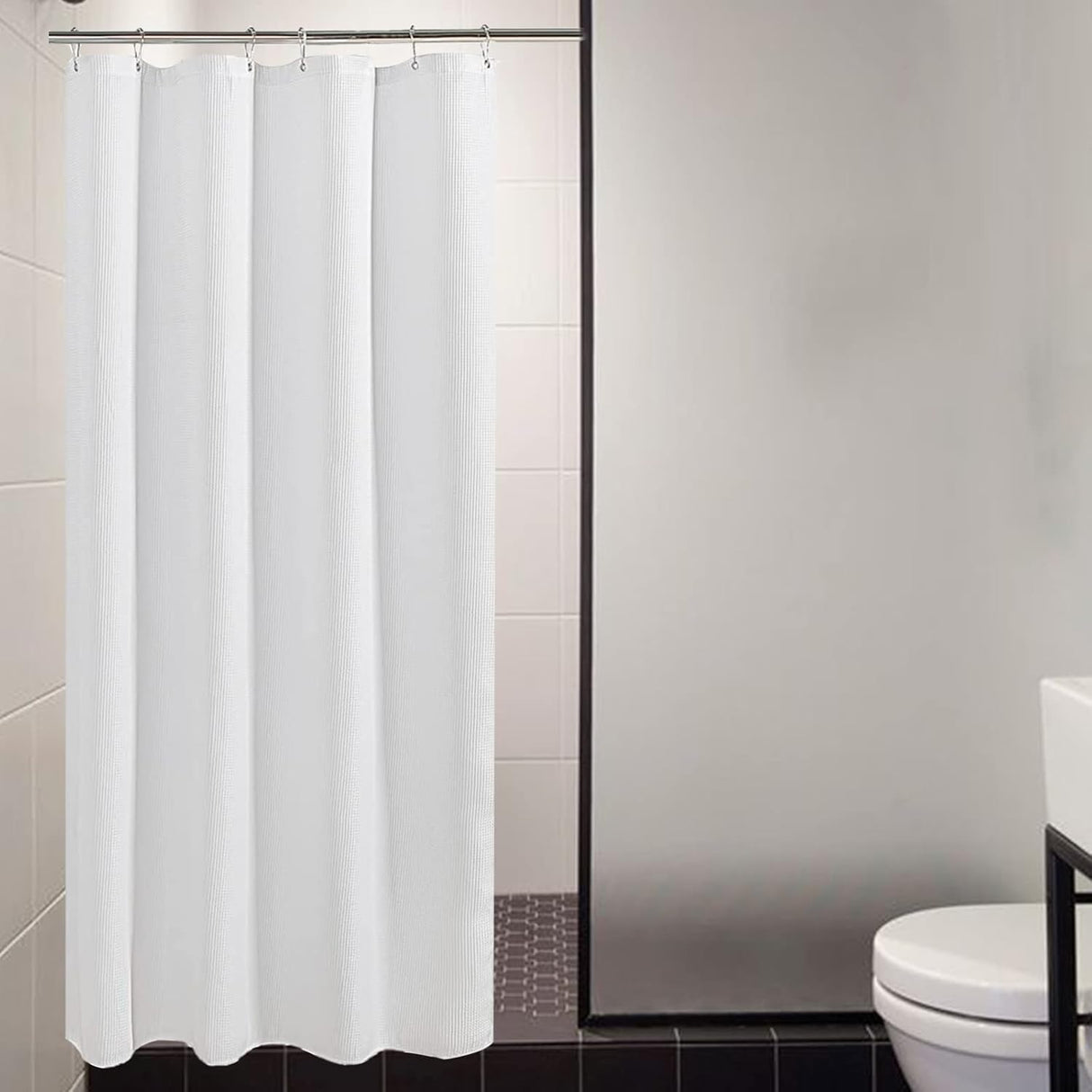 White shower curtain in a bathroom setting with tiled walls and a toilet.
