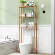 Bathroom with a bamboo wooden storage shelf against a green wall, holding various toiletries.
