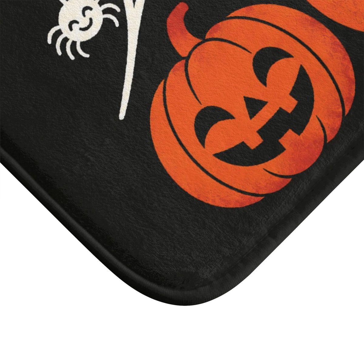 AmazerBath Halloween bath mat corner with spiderweb, bats, and three jack-o'-lanterns, vivid print, soft texture, and a bound edge.
