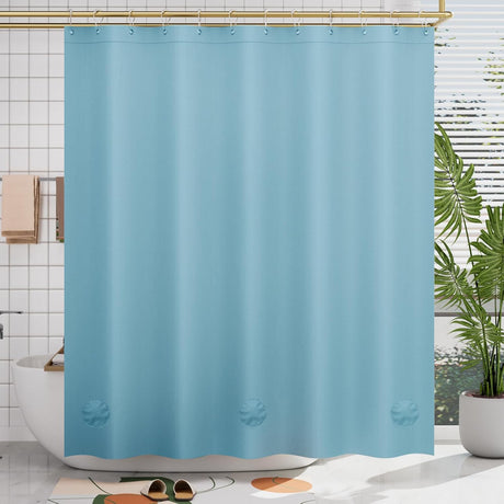 Blue shower curtain in a bathroom with a plant and bathtub.