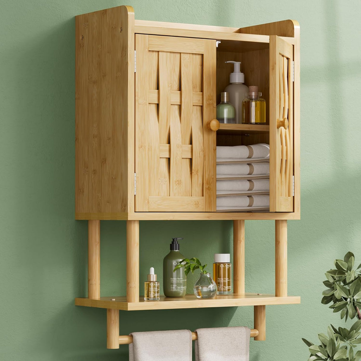 Bamboo cabinet with open doors displaying towels and bottles against a green wall.