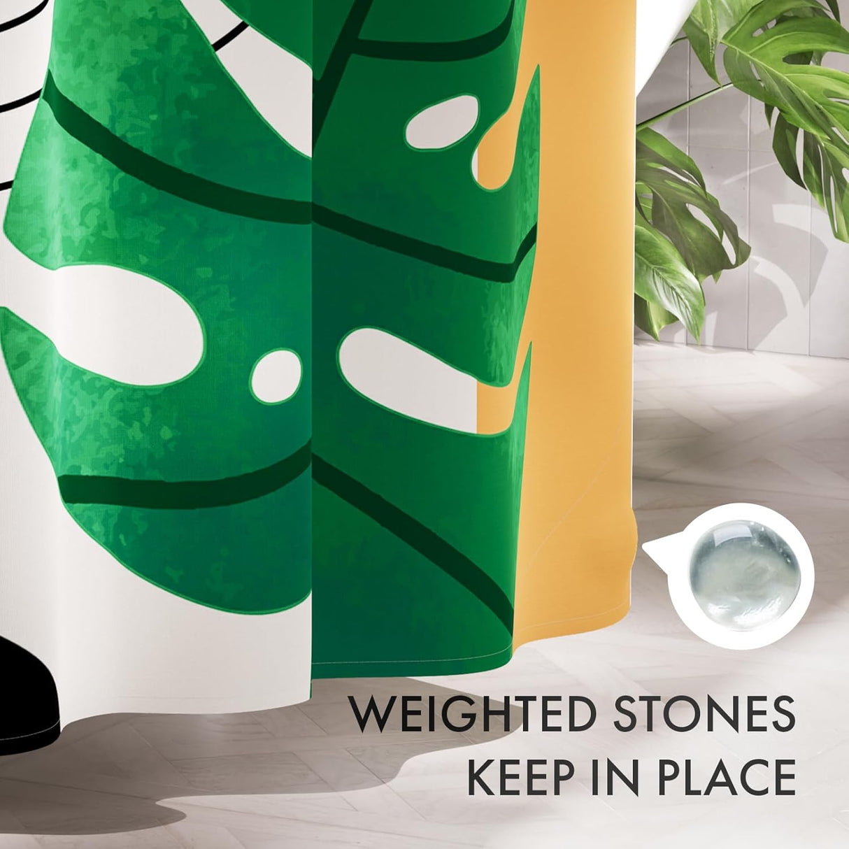 Green and yellow leaf-patterned shower curtain with text 'Weighted stones keep in place' on a bathroom floor.