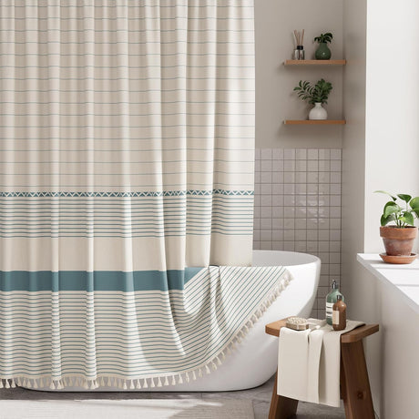 Striped shower curtain in a bathroom with a bathtub and shelves.