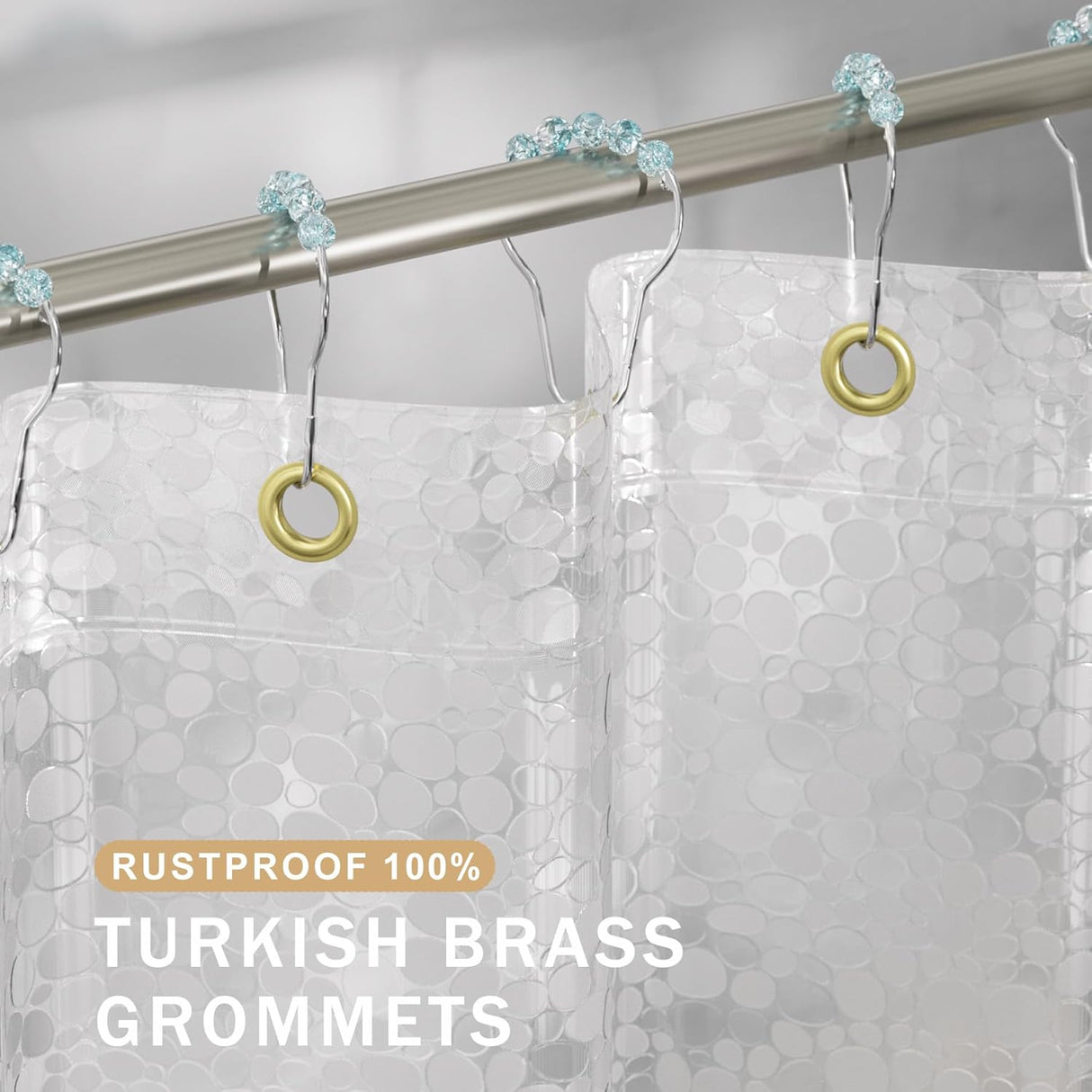 Clear shower curtain with gold and turquoise grommets on a silver rod.