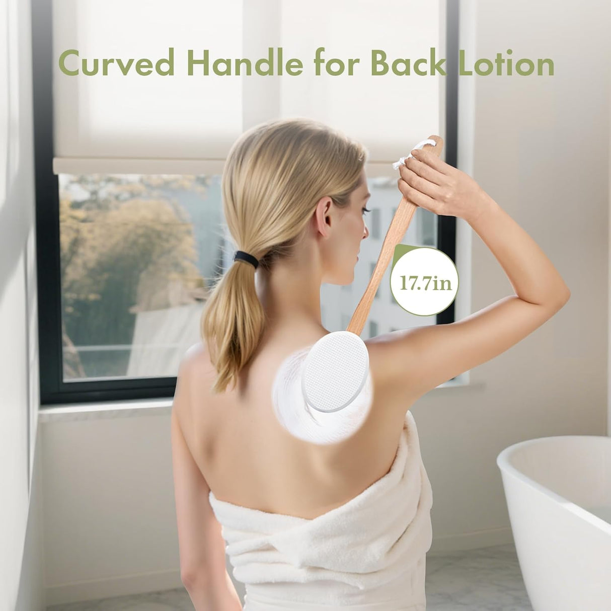 Woman applying lotion to her back with a curved handle applicator in a bathroom setting.