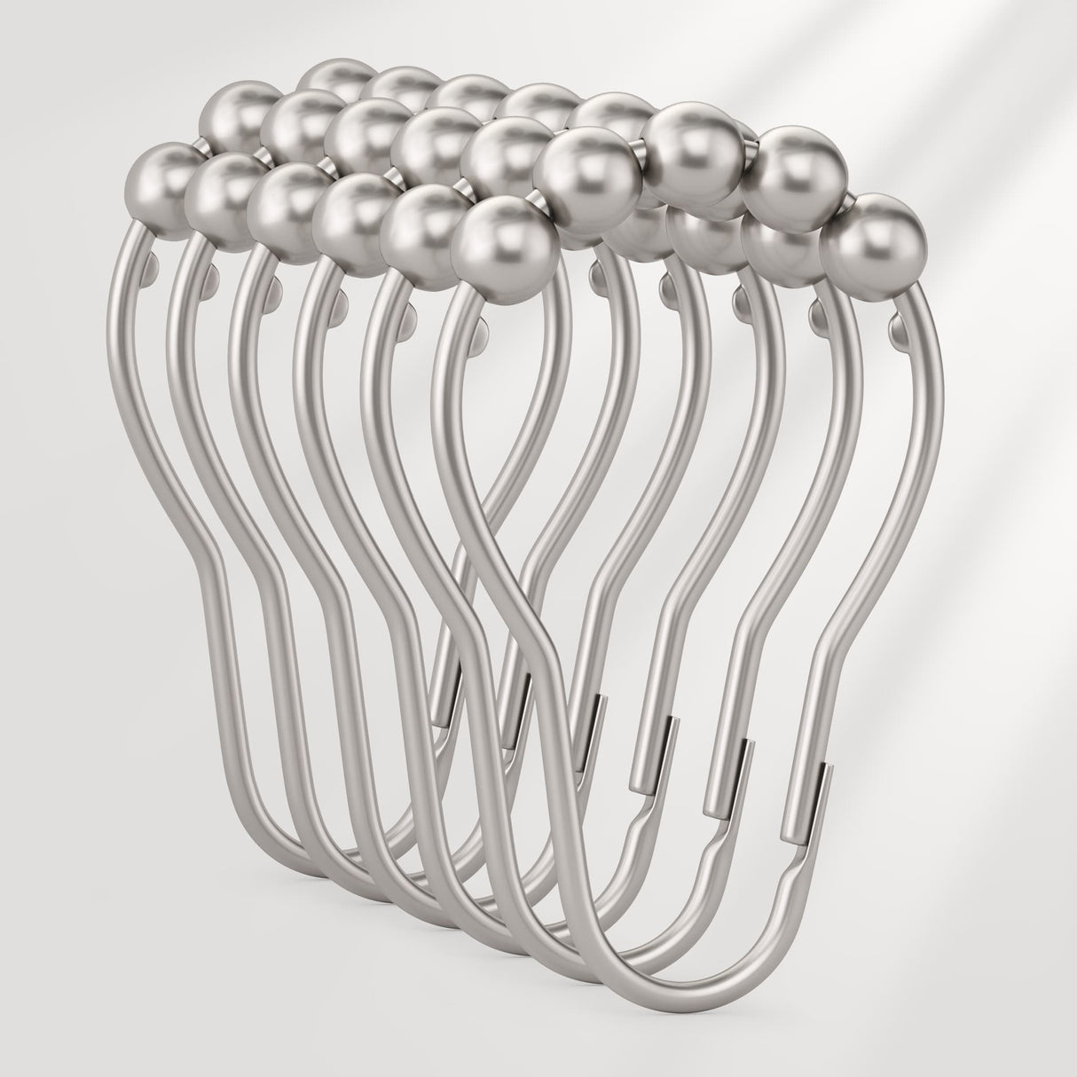 Metallic hair clip with pearl-like beads on a light gray background
