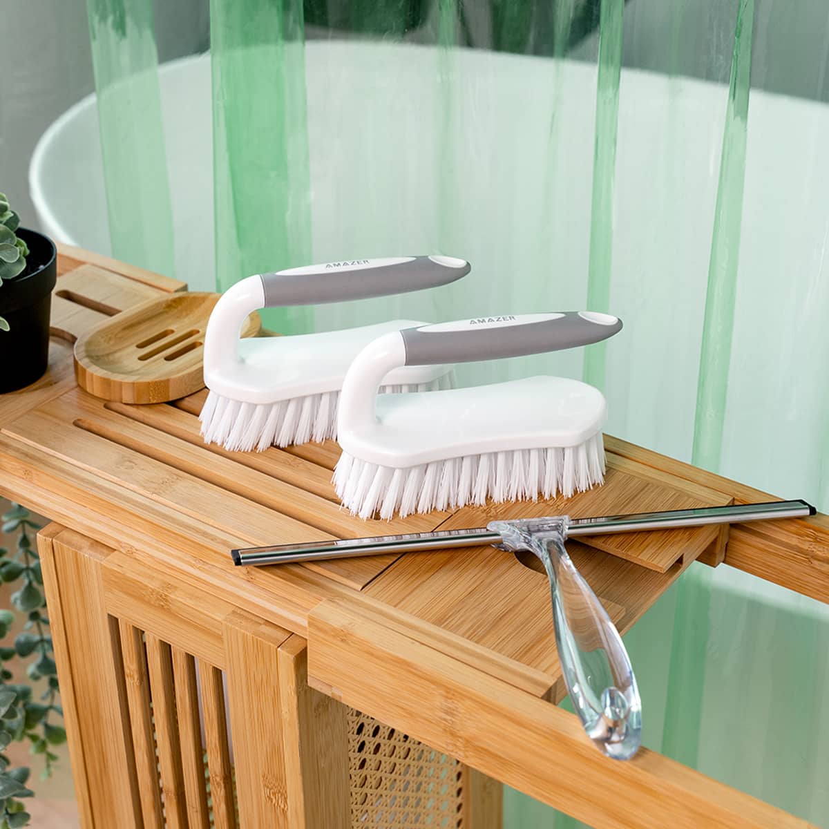 Cleaning brushes and squeegee on a wooden surface with a bathtub in the background