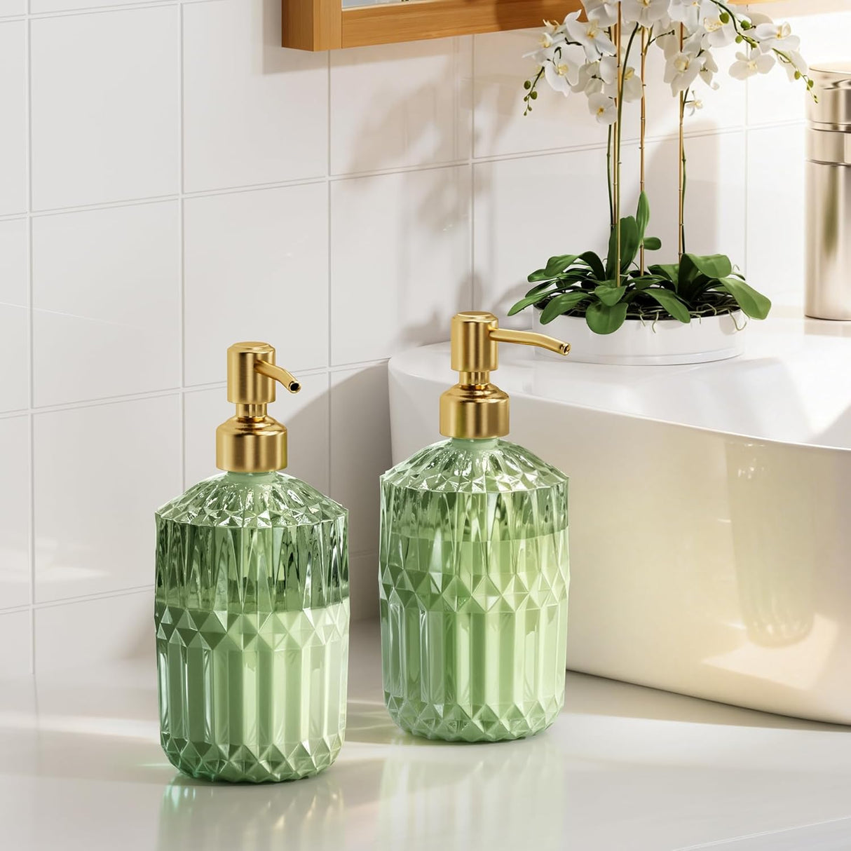 Two green diamond-patterned soap dispensers with gold pumps on a bathroom counter.