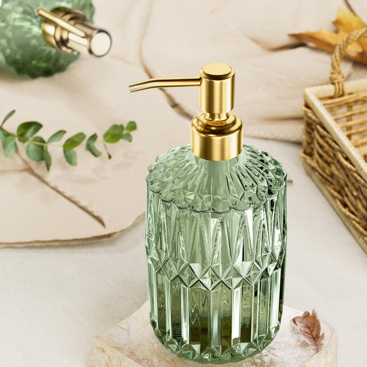 Green glass soap dispenser with gold pump on a neutral background