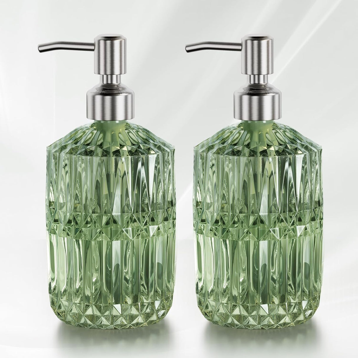 Two green glass soap dispensers with silver pumps on a white background