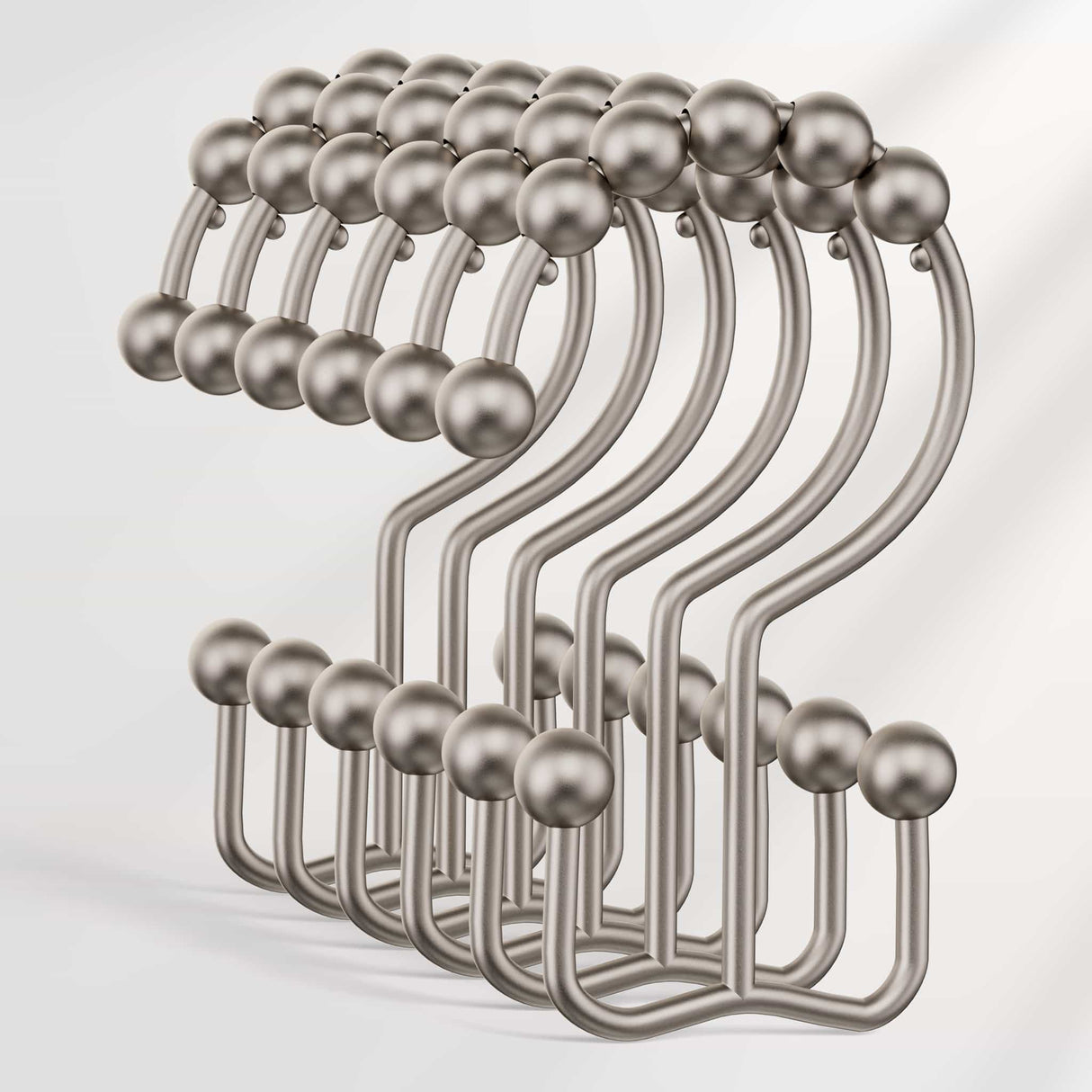 Set of metal hooks with spherical ends on a light gray background