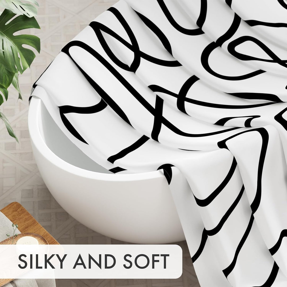 Close-up of the soft black abstract AmazerBath shower curtain fabric draped over a bathtub.