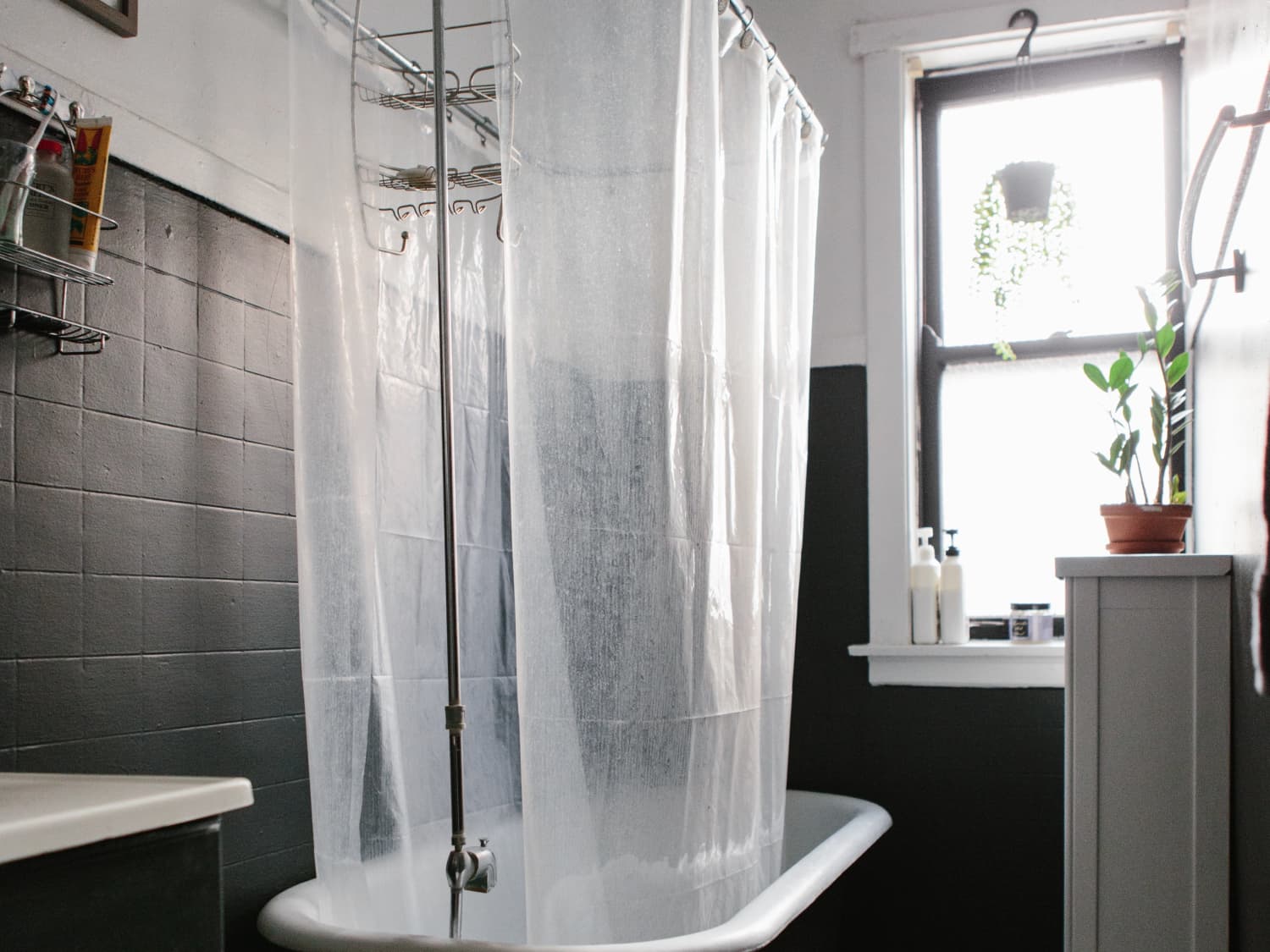 Clean shower curtain and liner hanging to dry in a bright bathroom