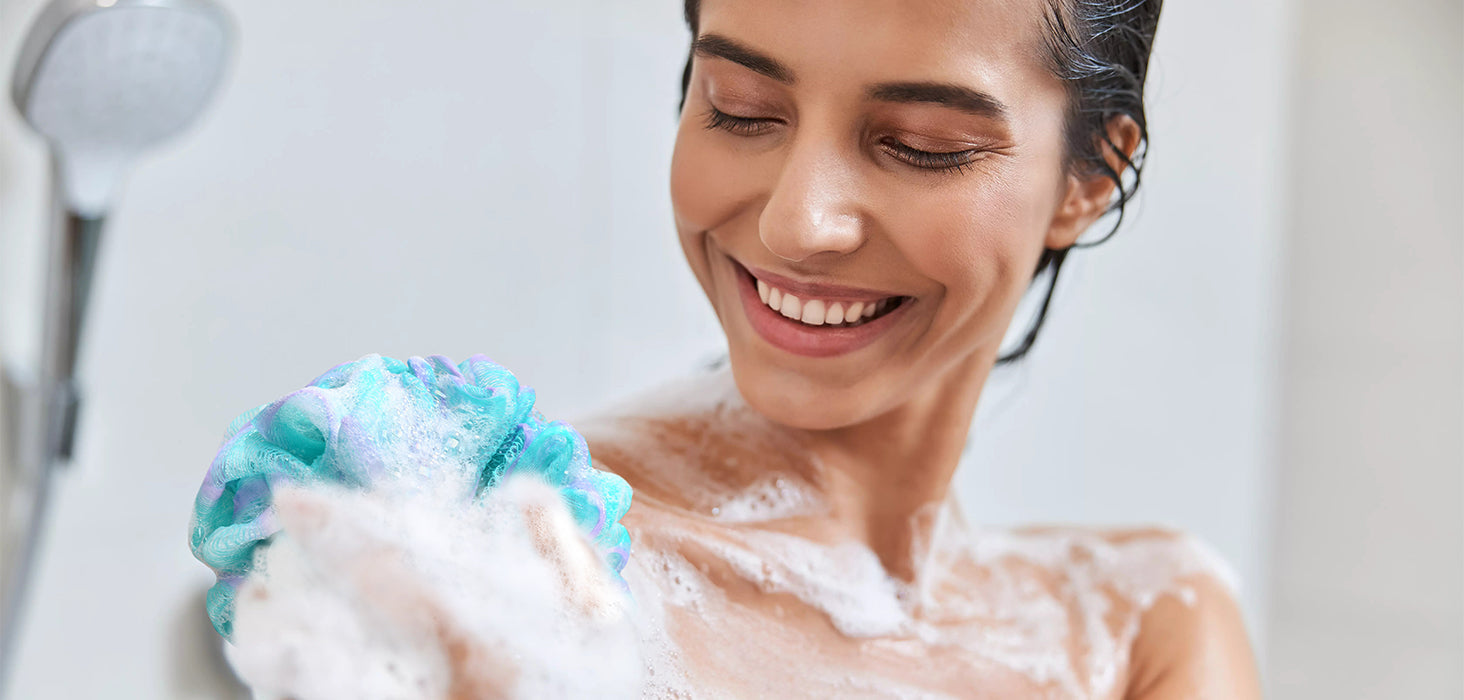 Woman using a colorful loofah sponge during a shower
