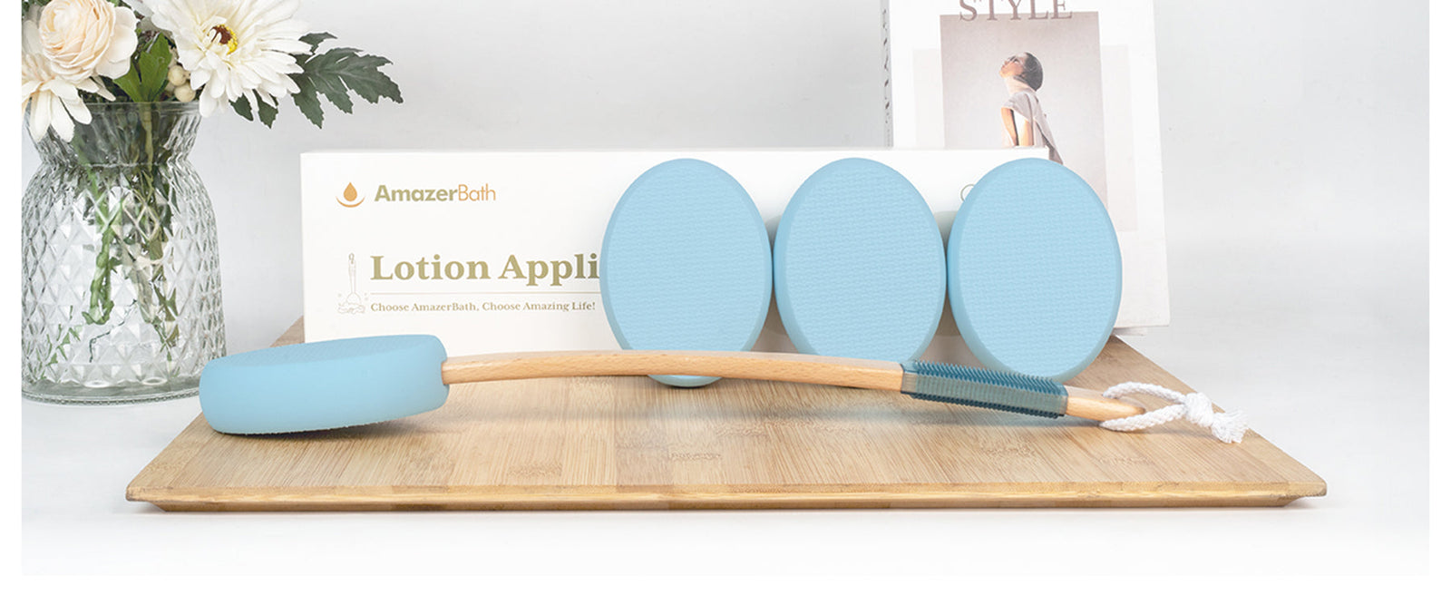 Blue long-handled lotion applicator with replaceable pads and product packaging