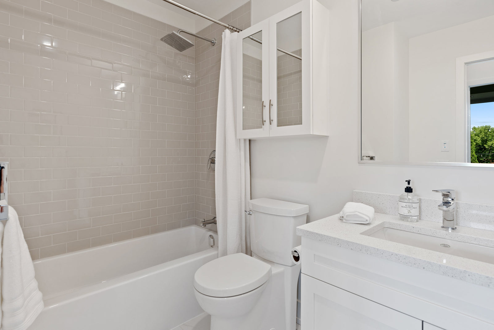 Bright small bathroom with a high-hung shower curtain emphasizing vertical space