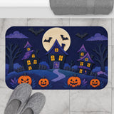 AmazerBath Halloween bath mat featuring haunted houses, full moon, and pumpkins placed on light bathroom tile beside a bathtub.