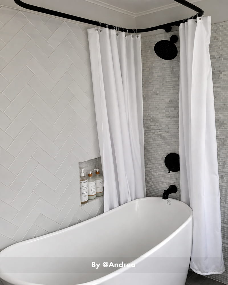 AmazerBath white 120 GSM fabric shower curtain liner hanging around a freestanding tub with matte black fixtures.