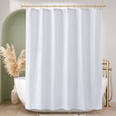 White shower curtain in a bathroom with a bathtub and decorative elements.