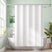 White shower curtain liner in a bathroom with a green wall and bathtub.