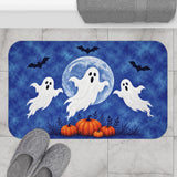 AmazerBath Halloween bath mat featuring blue moon, white ghosts, and pumpkins placed on light bathroom tile beside a bathtub.