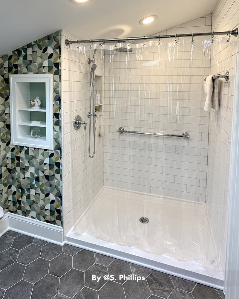 AmazerBath clear 12G PVC shower curtain liner enclosing a white tiled walk-in shower with a colorful mosaic accent wall.