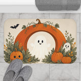 AmazerBath Halloween bath mat featuring white ghost, autumn wreath, and pumpkins placed on light bathroom tile beside a bathtub.
