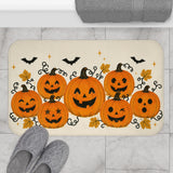 AmazerBath Halloween bath mat featuring orange jack-o'-lantern cluster on cream placed on light bathroom tile beside a bathtub.