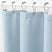 Light blue waffle-textured shower curtain with silver rings on a white background