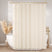 Beige shower curtain liner in a bathroom with a bathtub and decorative elements.