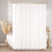 White shower curtain with gold fixtures in a bathroom setting