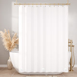 White shower curtain with gold fixtures in a bathroom setting