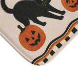 AmazerBath Halloween bath mat corner with black cats and jack-o'-lanterns on cream, vivid print, soft texture, and a bound edge.