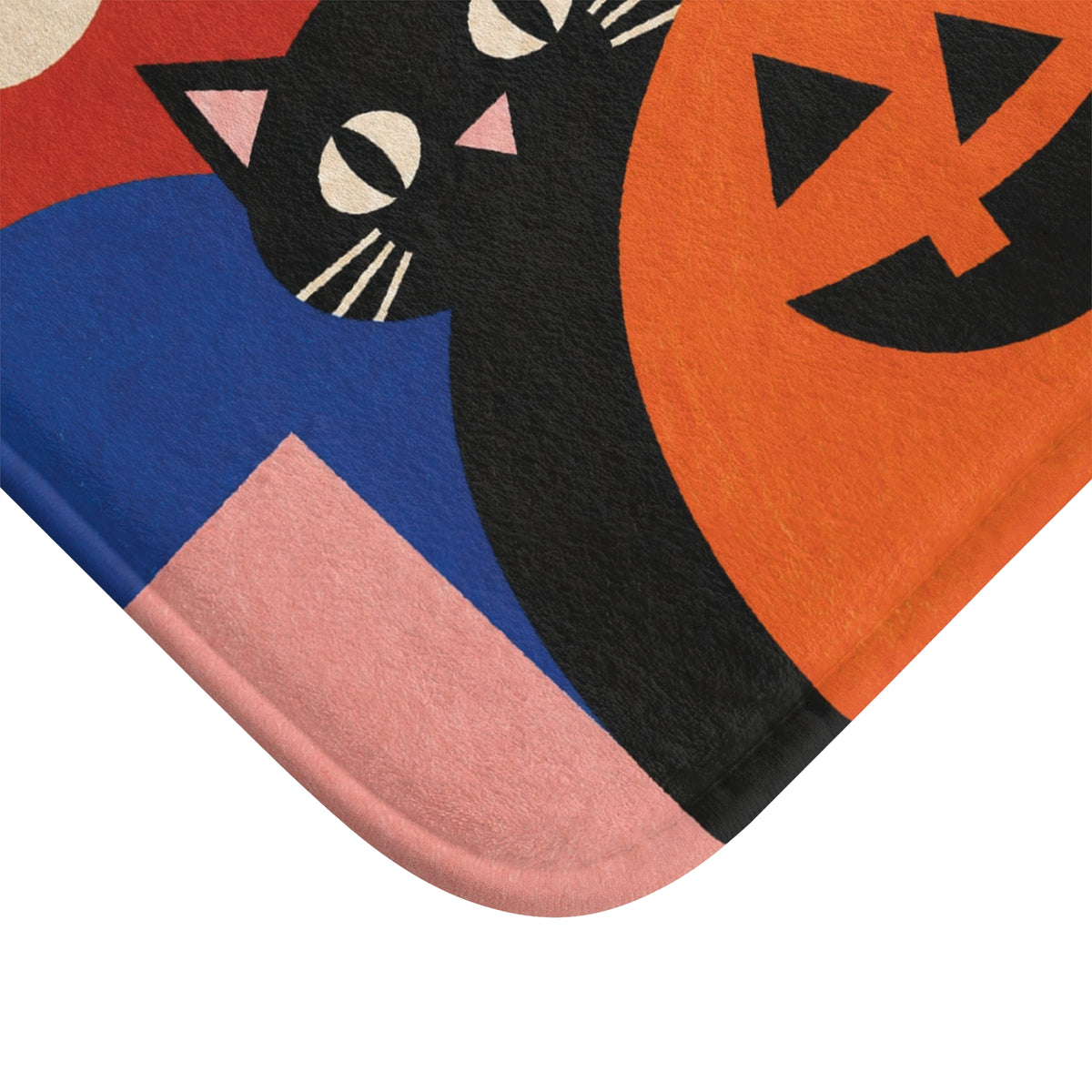 AmazerBath Halloween bath mat close-up with retro black cat, white ghost, and pumpkin, soft texture, and a rounded bound edge.