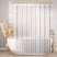 White shower curtain in a bathroom with a bathtub and decorative elements.