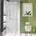 Modern bathroom with green tiled wall, white toilet, and shower curtain.