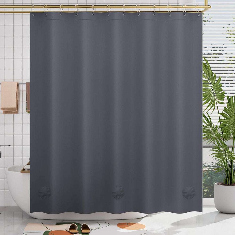 Gray shower curtain in a bathroom setting with a plant and bathtub.