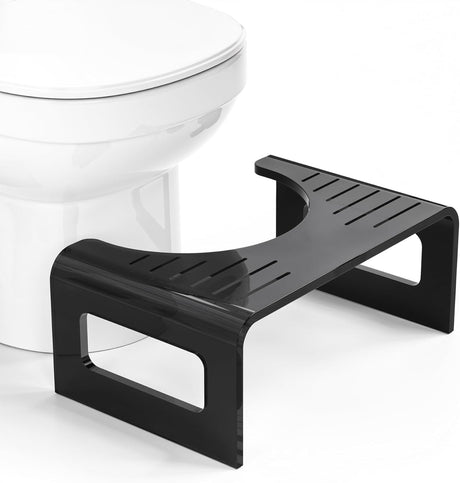 Black step stool in front of a white toilet on a white background