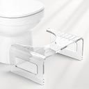 Clear acrylic step stool next to a toilet on a white background