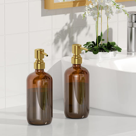 Two brown glass bottles with gold pumps on a bathroom counter.