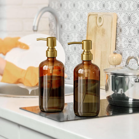 Two brown glass bottles with gold pumps on a kitchen counter.