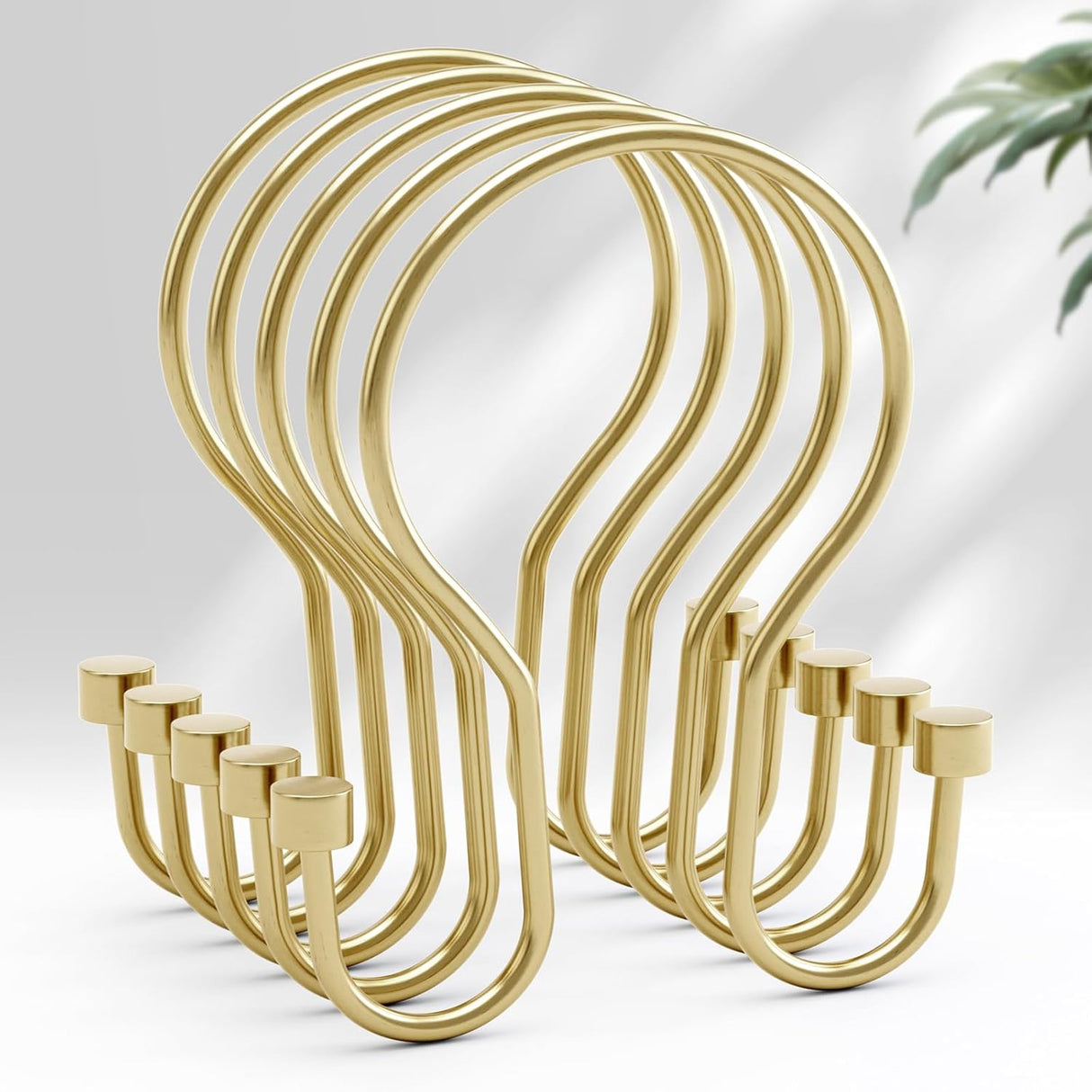 Set of gold metal hooks on a light gray background