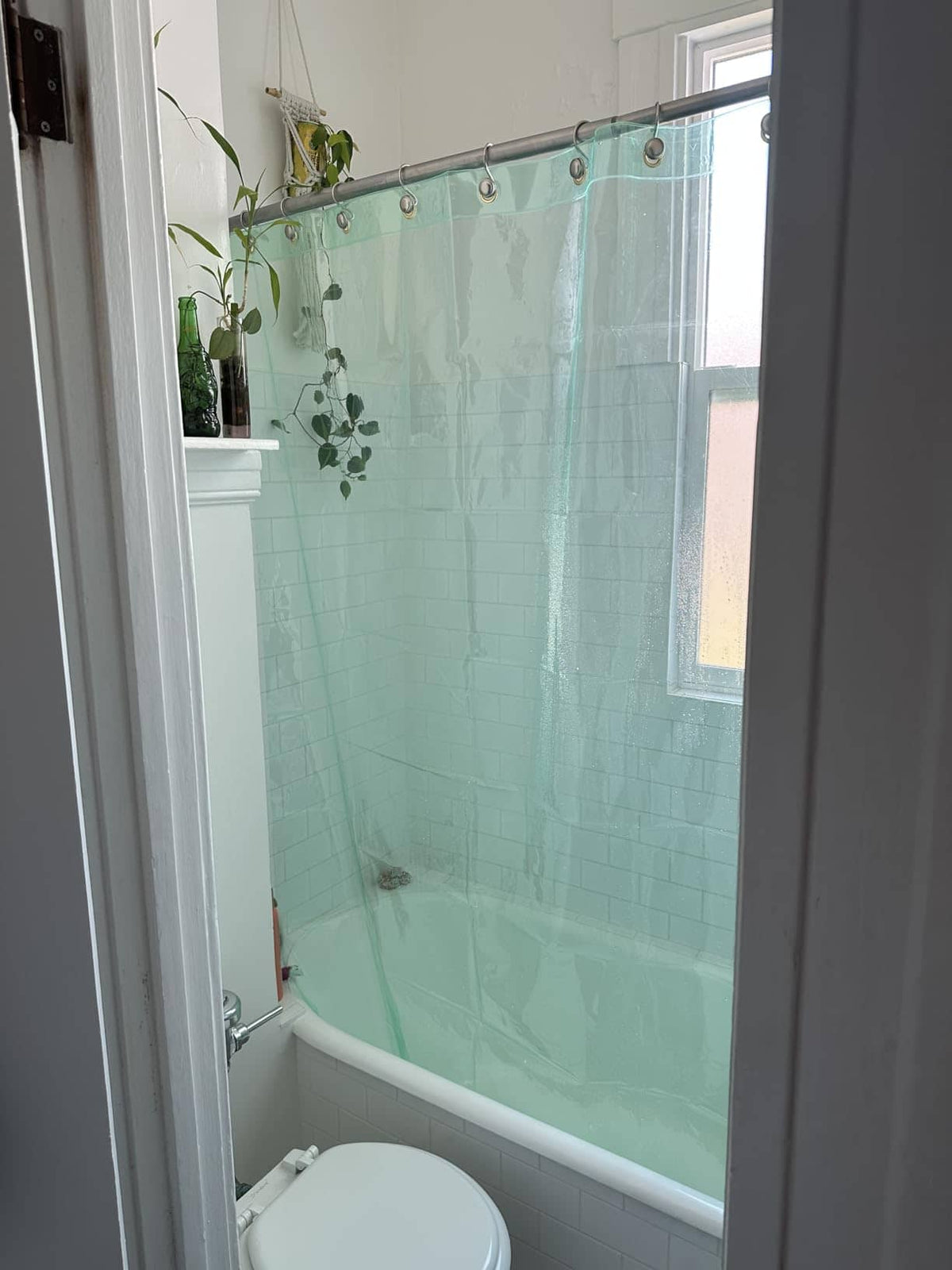 Aqua shower curtain in a bright bathroom with a window