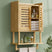 Bamboo wall-mounted cabinet with shelves against a green wall