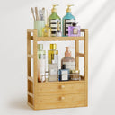 Bamboo storage shelf with various bottles on a white background