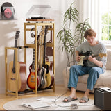 Person playing guitar in a living room with a guitar stand and record player.