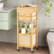 Bathroom storage cart with drawers and shelves against a tiled wall.
