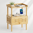 Wooden side table with a drawer, phone, and other items on a white background